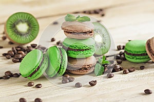 Green and brown french macarons with kiwi, coffee beans and mints decorations