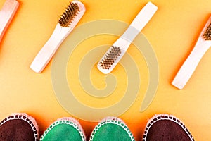 Green and brown suede espadrille shoes with brushes on yellow paper background.