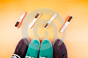 Green and brown suede espadrille shoes with brushes on yellow paper background.