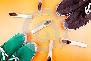 Green and brown suede espadrille shoes with brushes on yellow paper background.