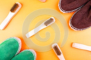 Green and brown suede espadrille shoes with brushes on yellow paper background.