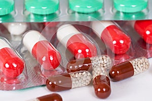 Green, brown and white-and-red antibiotic capsules