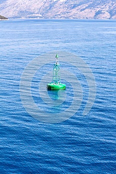 Green buoy floating in sea