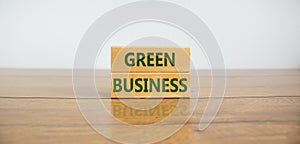 Green business symbol. Wooden blocks form the words `green business` on beautiful wooden table, white background. Business,