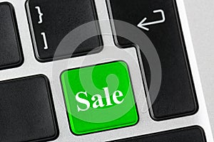 Green button with Sale word on the laptop keyboard. E-business concept.