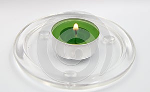 Green candle on glass suport