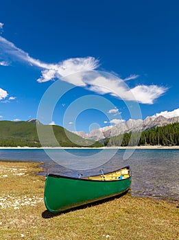 Green Canoe on the shore of a mountain lake