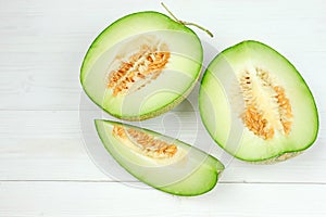 Green cantaloupe melon on white wooden.