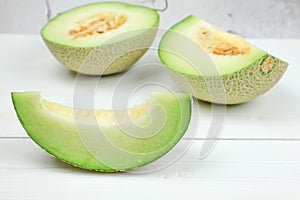 Green cantaloupe melon on white wooden