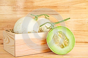 Green cantaloupe melon in wood box