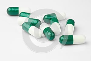 Green capsules and white antibiotic pills