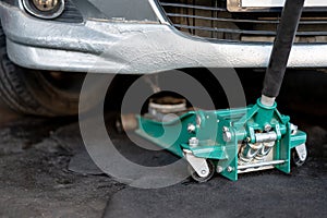 Green car jack or hydraulic floor jack in the garage