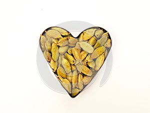 Green Cardamom pods defined heart shaped on white background, Top view photo