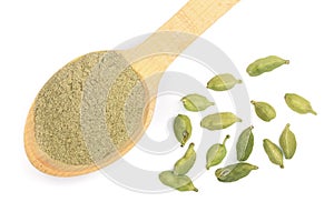 Green cardamom seeds and powder in a wooden spoon isolated on white background. Top view. lay flat