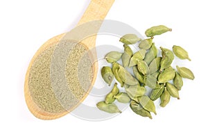 Green cardamom seeds and powder in a wooden spoon on white background. Top view. lay flat