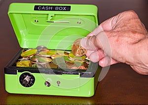 Green cash box with gold and silver coins