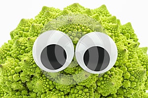 Green cauliflower with googly eyes on white background