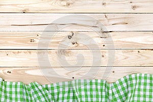 Green checkered tablecloth on wooden table, top view
