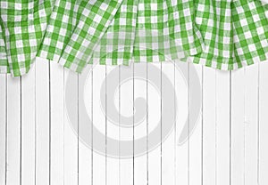 Green checkered tablecloth on wooden table, top view