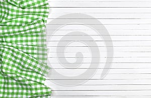 Green checkered tablecloth on wooden table, top view