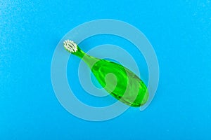 Green childrens toothbrush. on a blue background. Place for an inscription. Toothbrushing a child