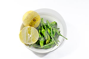 Green chili and yellow lime lamon on the white background