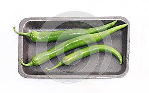 Green chilly peppers on tray