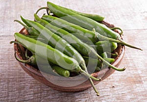 Green chilly on wooden background