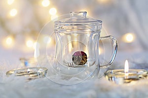 Green chinese tea flower bud blooming in glass tea cup on bokeh background.