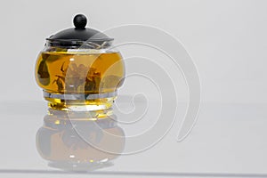 Green Chinese tea flower bud blooming in glass teapot. on white background