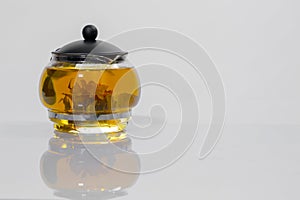 Green Chinese tea flower bud blooming in glass teapot. on white background