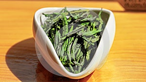 Green Chinese tea Luanguapian Liuan Leaf, LuÃ¢â¬â¢an Melon Seed in Tea presentation vessel photo