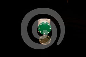 Green chips stack with a White chip in front isolated on black with reflection