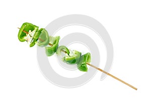 Green chopped sweet bell pepper with wood skewer isolated on white background