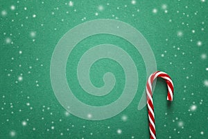 Green Christmas background with red candy canes. Copy space for text.