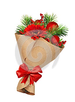 Green Christmas pine twigs and red berries of winterberry Holly, flowers and decorative balls in a craft paper cornet isolated on