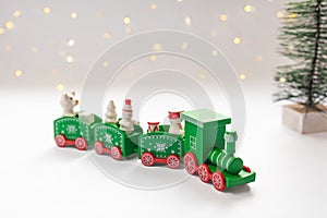 Green christmas train, fir tree and blurry bokeh lights in the background