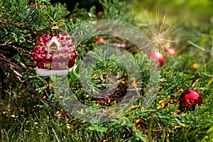 Green Christmas Tree Decorated With Red Balls.red ornaments hanging from a decorated Christmas tree.Magic sparkling