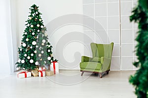 Green Christmas tree with gifts in the interior of the white room New Year
