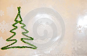 Green christmas tree from tinsel on snowflakes white background. snowy winter weather. merry christmas. xmas congratulation time.