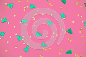 green christmas trees and gold stars confetti sparse on pink background