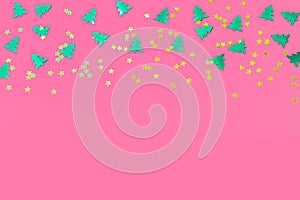 green christmas trees and gold stars confetti sparse on pink background