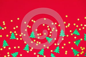 green christmas trees and gold stars confetti sparse on red background