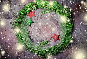 Green Christmas wreath with stars decorations on dark background.