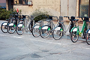 Green city bikes for rent in an urban bicycle rental station