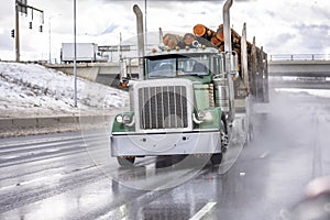 Grün klassisch der große ausrüstung halbfertige produkte LKW transport protokolle auf der halbfertige produkte anhänger laufen auf der breit nass Straßen schmelzen der schnee a Wasser 