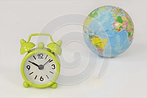 Green clock and planet earth on white