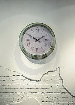 Green Clock with Roman numerals on cracked brick wall