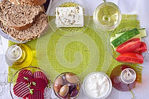 Green cloth background with the space for a text. Traditional Mediterranean motive - feta cheese, tzatziki, olives