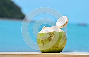 Green coconut drink on tropical beach